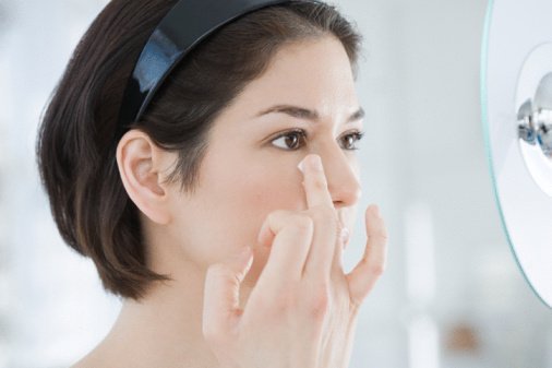 Woman applying moisturiser